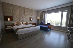 MandyaHotel Amaravathi的有一张大床和一扇窗户的酒店房间