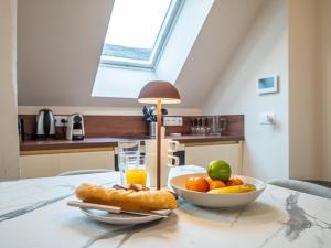 una mesa con un tazón de fruta y un tazón de zumo de naranja en OIQIA • Palace Hôtel • N°4, en Tours