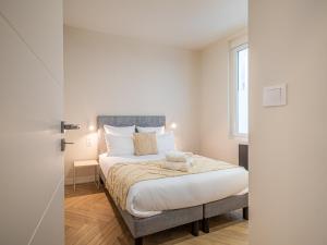 Un dormitorio con una cama con sábanas blancas y una ventana. en OIQIA • Palace Hôtel • N°4, en Tours