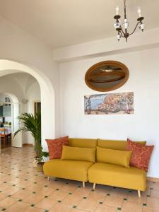 a yellow couch in a living room with a ceiling at Positano's Flats in Positano