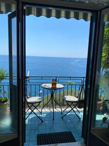 a balcony with a table and chairs and the ocean at Positano's Flats in Positano