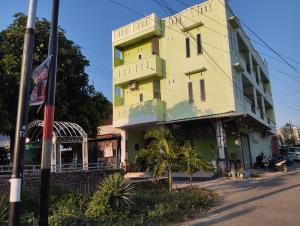 a yellow and green building on the side of a street at Hotel O Penginapan Permata Hijau Syariah Near Bukit Teletubbies in Parepare +22 photos