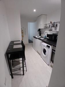 cocina con mesa y lavadora en Flat 2 - Eign St Hereford, en Hereford