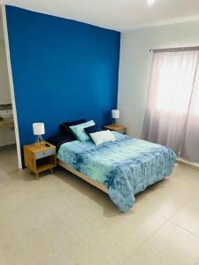 a blue bedroom with a bed and two night stands at Depa en Cancun con alberca in Cancún