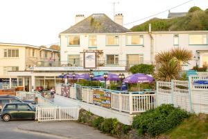 a building with purple umbrellas in a parking lot at Sandcastles 11 Europa Court in Mawgan Porth in Mawgan Porth
