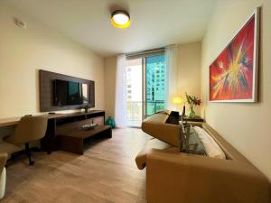 a living room with a couch and a desk and a television at Splendid apartment for 4 pax partial view of the beach in Hollywood M in Hollywood +53 photos