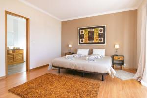a bedroom with a bed in a room with a rug at Liv In by Ericeira Property in Santo Isidoro