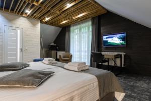 a bedroom with a large bed with towels on it at Voevodyno Resort in Turʼya Paseka +123 photos