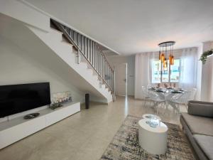 een woonkamer met een bank, een tv en een tafel bij Salinas Luxury DaNuria in Torrevieja