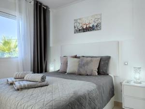 een slaapkamer met een bed met twee kussens erop bij Salinas Luxury DaNuria in Torrevieja +24 foto's