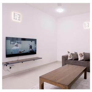 a living room with a flat screen tv on a wall at Diyawanna Villa - Deluxe Double Room in Colombo in Sri Jayewardenepura Kotte +37 photos