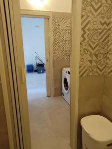 a bathroom with a toilet and a washing machine at Casa Acqua Marina in Bisceglie +10 photos