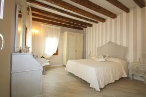 1 dormitorio con cama blanca y paredes a rayas en Terrazza Biennale, en Venecia