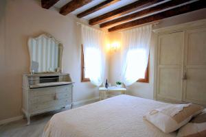 a bedroom with a bed and a dresser and a mirror at Terrazza Biennale in Venice