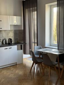 Una cocina y un comedor con mesa y sillas. en Apartamenty 649 metrów od Dworca, en Przemyśl