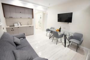 Una sala de estar con un sofá y una mesa con sillas. en GQ Luxe Apartments In Alliance Palace, en Batumi