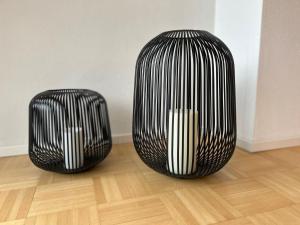two black and white vases sitting on a wooden floor at Ferienwohnung Kirschgarten mit Infrarot-Kabine in Aschau im Chiemgau