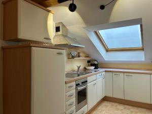 a kitchen with a window and a sink and a stove at Ferienwohnung Kirschgarten mit Infrarot-Kabine in Aschau im Chiemgau
