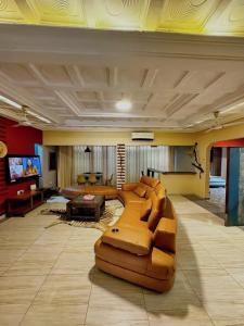 AkropongEn-suite Ecolodge Room with Views of Safari Valley的配有沙发和电视的大客厅