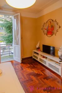 un soggiorno con TV a schermo piatto e pavimento in legno di Garden Fiore del Ducato a Parma