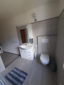 a bathroom with a sink and a toilet and a mirror at Casa relax Berchida in Capo Comino