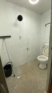 baño con aseo y una luz en la pared en Homestay Jelai, en Gemas