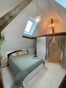 a bedroom with a bed and a window at LAtypique in Beaumont-sur-Sarthe