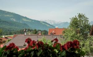 a view of a house with mountains in the background at Pretzners Ferienwohnungen in Reit im Winkl