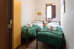 two twin beds in a small room with a window at Essenza di Zagara, 5min dalle spiagge e porto in Trapani