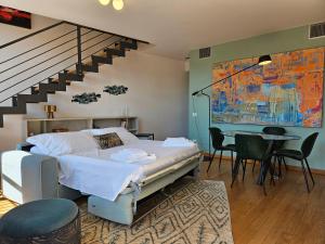 a bedroom with a bed and a table and a staircase at Borgo Verde Centro Storico Lucca in Lucca
