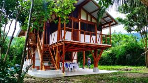 a tree house with a woman standing in front of it at Hospedaje piedras de agua in Santa Marta