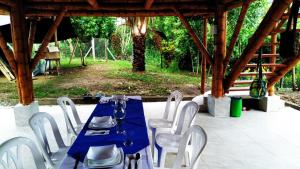 a blue table and white chairs in a pavilion at Hospedaje piedras de agua in Santa Marta +2 photos