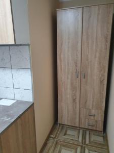 a kitchen with a wooden cabinet in the corner at Double Lux Aparrment A1 in Pancevo in Pančevo