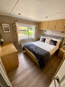 a bedroom with a large bed and a window at Limestone Lodges in Bothel +31 photos