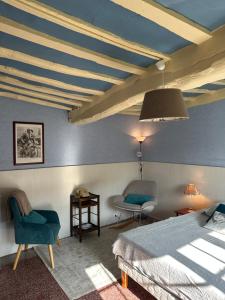 a bedroom with a bed and a table and chairs at Gîte la Floria in Sotteville-sur-Mer