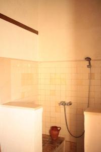 a bathroom with a shower in a white tiled wall at The House In the Hillsides Hillsides in Pampilhais de Baixo