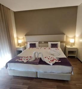 a bedroom with a large bed with flowers on it at Hotel Monte Lírio in Espinho