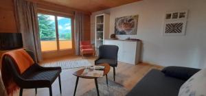 een woonkamer met een bank, stoelen en een tafel bij Winklgut Bacher in Uttendorf
