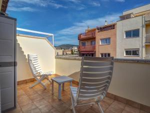 two chairs and a stool on the balcony of a building at Ribes Duplex by Hello Homes Sitges in Sitges