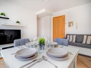 a white dining room with a white table and chairs at Ribes Duplex by Hello Homes Sitges in Sitges