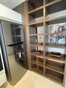 cocina con nevera y estanterías de madera en Apartment Miami Tower Premium Villa Morra, en Asunción