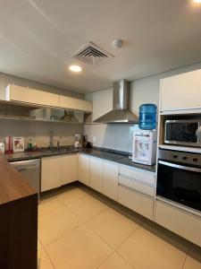 Una cocina con gabinetes blancos y un horno de estufa. en Apartment Miami Tower Premium Villa Morra, en Asunción