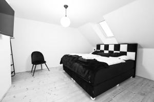 a black and white bedroom with a bed and a chair at House Werich in Mikulov