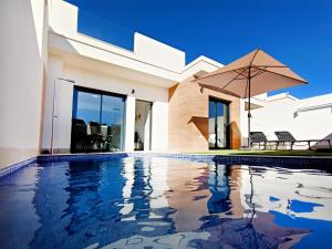 トレ・パチェコにあるDolores Villa - 5210の傘付きのスイミングプールのある家