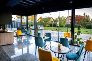 ein Restaurant mit Tischen, Stühlen und Fenstern in der Unterkunft Burgundy in Ploieşti