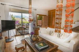 a living room with a white couch and a tv at Alegre Playa Grupo Terra De Mar in Calpe