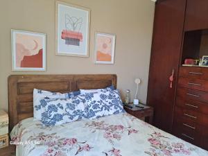 a bedroom with a bed with blue and pink flowers at Apartmento completo em Botucatu SP in Botucatu