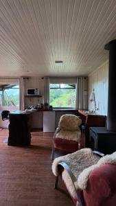 una sala de estar con un sofá y una mesa en Chalé 10 com hidromassagem Kayser Haus, en Urubici