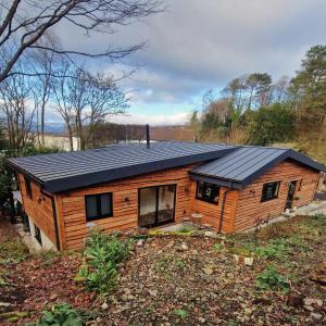 a log cabin with a solar roof on a field at Cedar Lodge in Bowness-on-Windermere
