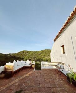 a patio with white couches on top of a building at The House In the Hillsides Hillsides in Pampilhais de Baixo